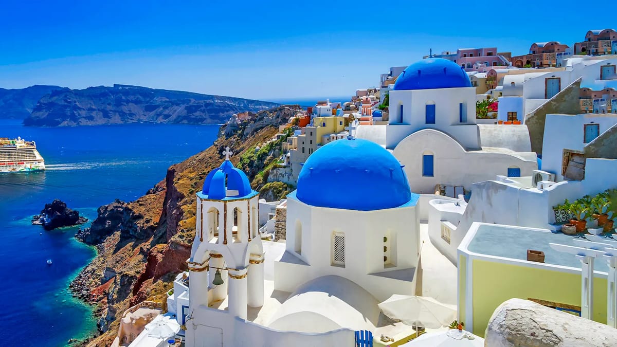 A cruise ship at anchor in the caldera below the cliff of Santorini
