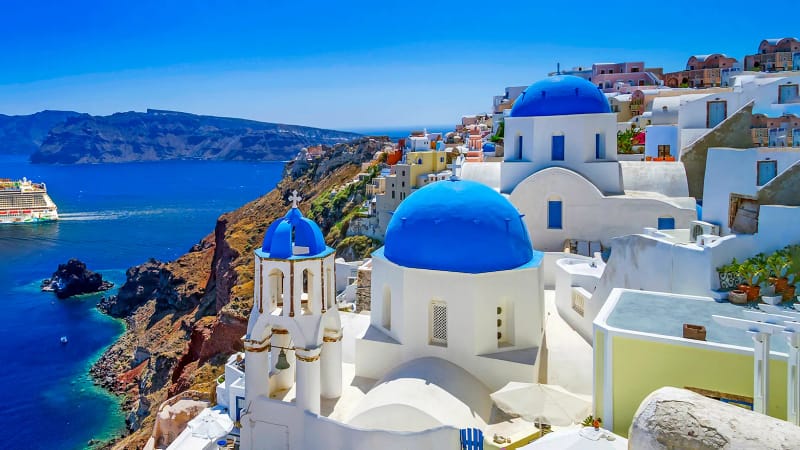 A cruise ship at anchor in the caldera below the cliff of Santorini
