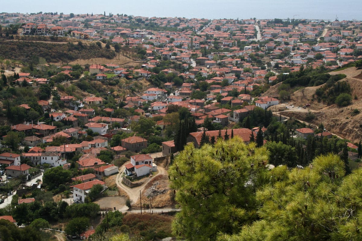 Old Nikiti on its hill with the cemetery church in the foreground, the modern village and the Toroneos gulf behind