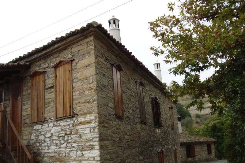 A stone house with wooden shutters in the old quarter of Nikiti