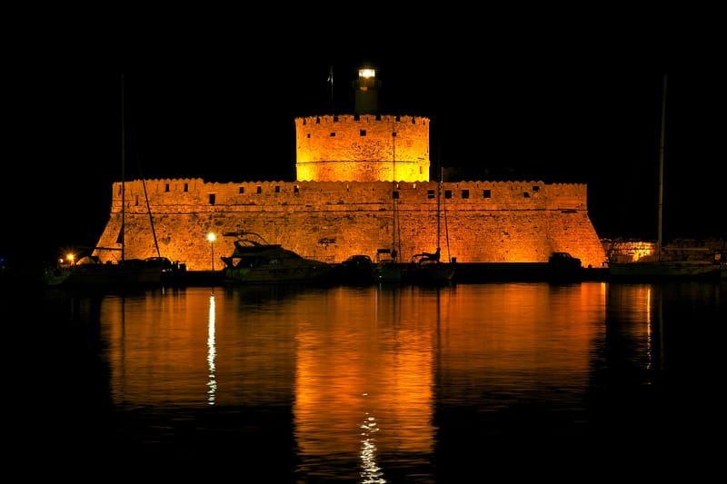 The lighthouse of fort Saint Nicolas (Agios Nikolaos), at work by night, harbour of Rhodes, Greece