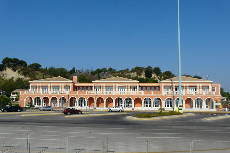 The long arcaded building at the port of Corfu, the car park and the road in front of it