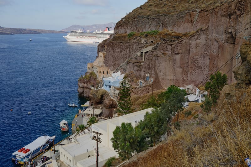 The old port of Fira from the Karavolades steps: the tender quay, a cruise ship at anchor behind it