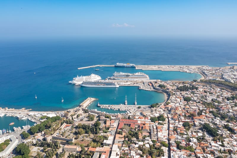The cruise port of Rhodes from the air: three ships alongside the quays of the Tourist Harbour, the walls of the Old Town beside it